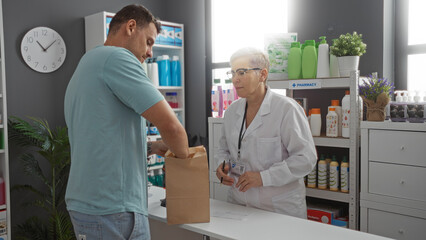 Obraz premium Man interacting with woman pharmacist indoors at pharmacy counter with various products on shelves in background