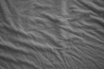 Texture of Dark grey crumpled textile cloth part with small folds