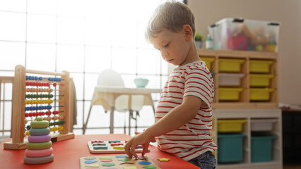 Toddler boy playing with educational toys in a bright kindergarten indoor setting, exploring shapes...