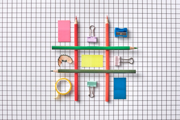 Creative Flat Lay of Colorful Stationery on Grid Paper Background
