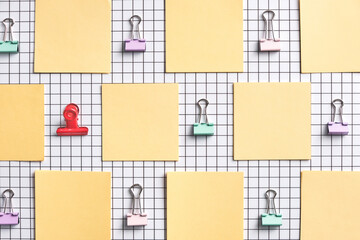 Colorful Paper Clips and Sticky Notes on Checkered Background