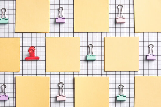 Colorful Paper Clips and Sticky Notes on Checkered Background