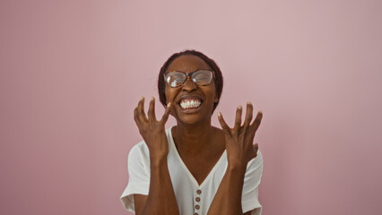 Woman expressing excitement wearing glasses smiling joyfully over isolated pink background