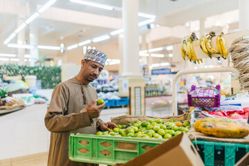 Omani man choosing limes in traditional market