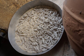 Traditional handmade cretan skioufikta pasta floured in a pan next to a clay pot ready to be cooked - Gretan cuisine