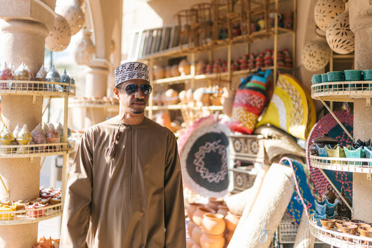 Omani man walking in traditional market exploring local crafts