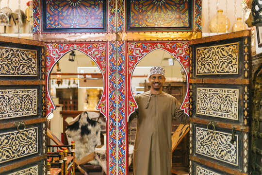 Omani shopkeeper welcoming customers at traditional market stall