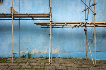 Scaffolding by a blue wall