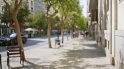 Outdoor scene with blurred trees and buildings along a sunny sidewalk in a city street with shadows