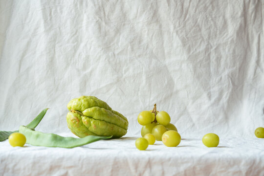 Fresh Produce Arrangement with Chayote and Grapes on White Fabric