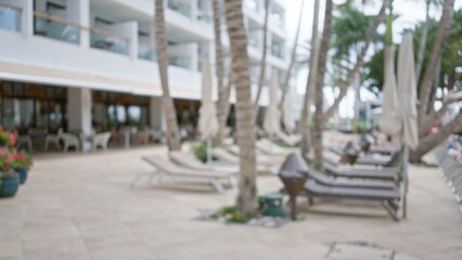 Defocused view of a tropical resort with chairs and palm trees, capturing a blurry, bokeh background of the luxurious setting