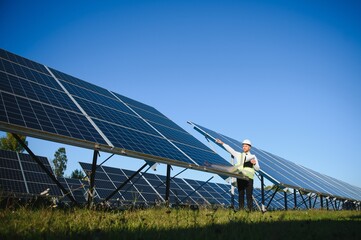 Solar power plant. Man standing near solar panels. Renewable energy