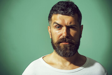 Obraz premium Man portrait. Handsome bearded man with stylish hairdo, closeup portrait. Serious pensive man with beard and mustache in casual clothes. Fashionable unshaven man in white sweater. Fashion male model.