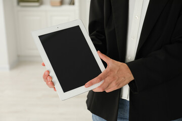 Businesswoman with tablet indoors, closeup. Modern technology