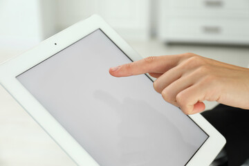 Businesswoman using tablet indoors, closeup. Modern technology