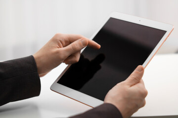 Businessman using tablet on blurred background, closeup. Modern technology