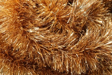 Shiny golden tinsel as background, closeup view