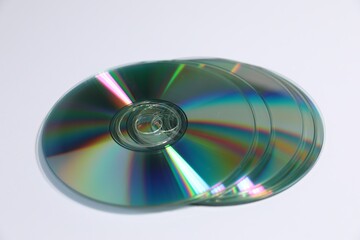 Many shiny compact discs on light background