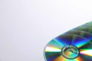 Many shiny compact discs on light background. Space for text