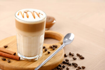 Tasty latte macchiato in glass on wooden table, closeup. Space for text