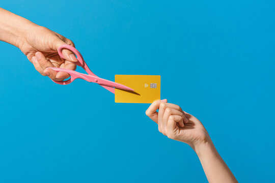 Cutting Credit Card with Pink Scissors on Blue Background