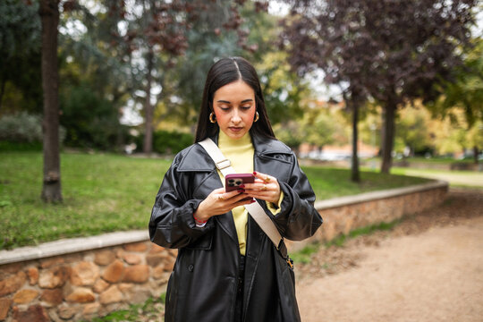 generation z woman using mobile phone outdoors