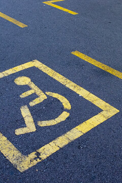 Disabled invalid sign symbol painted in the street in urban city 