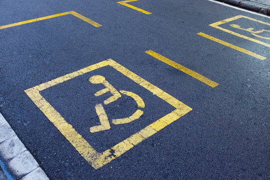 Disabled invalid sign symbol painted in the street in urban city 