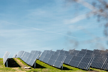 Photovoltaic solar panel array on hillside under clear sky