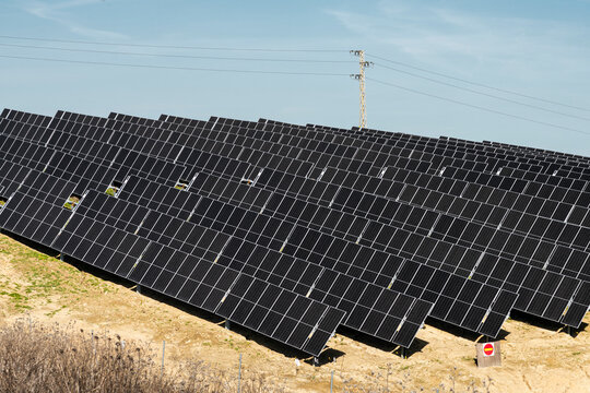 Solar panels and power lines in rural field