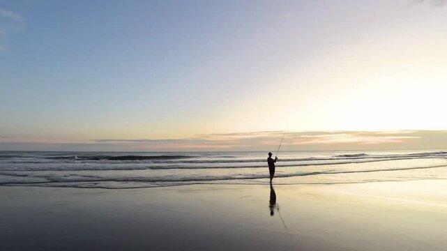 sunset on the beach fisher man fishing