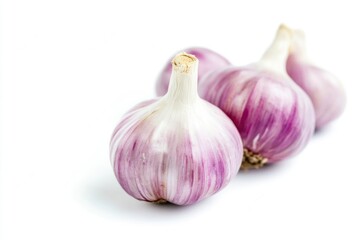 Obraz premium Close-up of three garlic bulbs on a white background