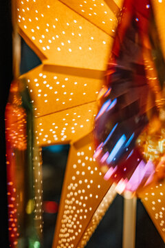 Brightly colored star decoration illuminated at night.