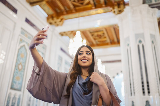 Tourist taking selfie at sultan qaboos grand mosque
