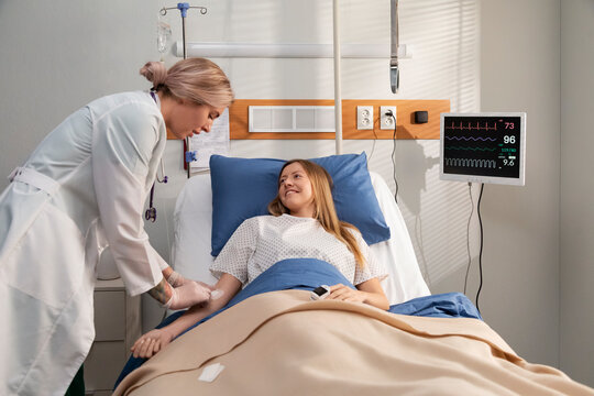 Doctor applying bandage on patient's arm in hospital room