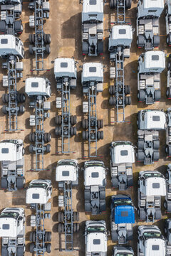 Aerial view of a neatly arranged fleet of semi trucks in a parki