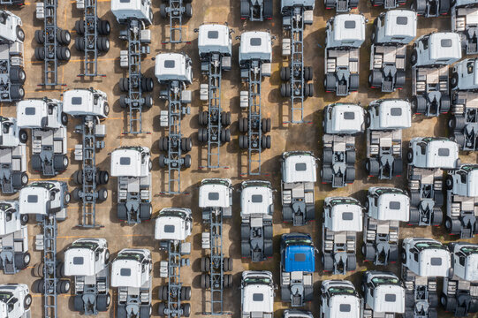 Aerial view of a neatly arranged fleet of semi trucks in a parki