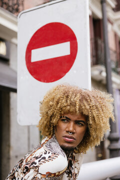 Confident fashion statement with urban backdrop and defaced sign