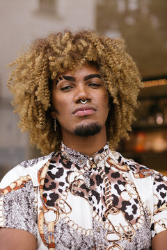 Portrait of a Stylish gay man with Curly Hair and Piercings