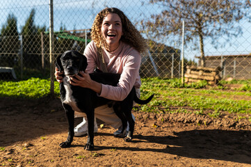Volunteer hugs stray dog in animal shelter