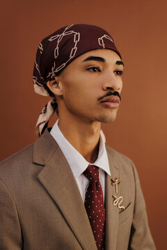 Elegant man wearing suit and do rag posing in studio