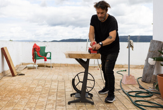 Man using power tool to treat wood