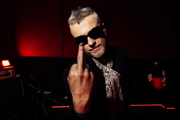 Rock music attitude in a red-lit room with sunglasses