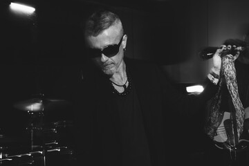 Mysterious Rock Singer Performing Under Dim Stage Lights