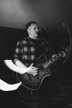 Black and white photo of guitarist performing on stage