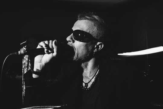 Black and white rock singer performing with microphone on stage
