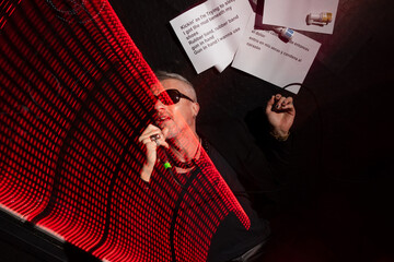 Energetic singer performing under vibrant red stage lights