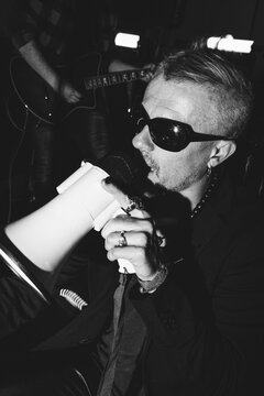 Expressive rock singer performing with megaphone on stage