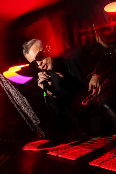Energetic rock performance with vibrant red lighting effects