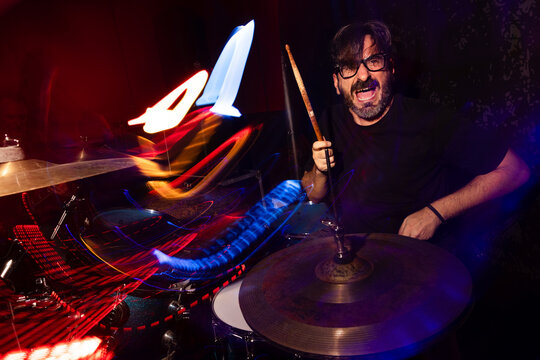 Energetic Drummer Performing with Vibrant Light Trails